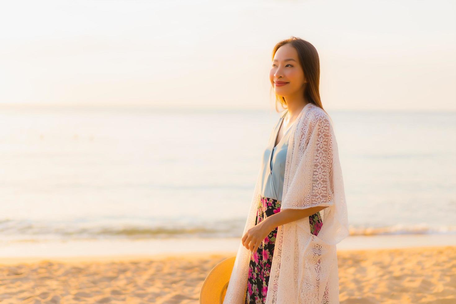 ritratto belle giovani donne asiatiche sorriso felice rilassarsi intorno alla spiaggia mare oceano foto