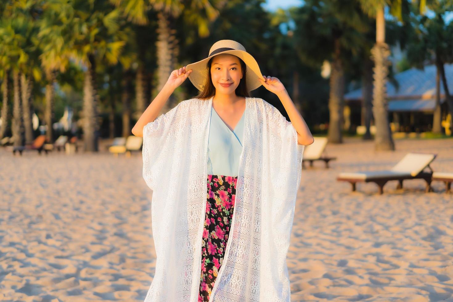 ritratto belle giovani donne asiatiche sorriso felice rilassarsi intorno alla spiaggia mare oceano foto