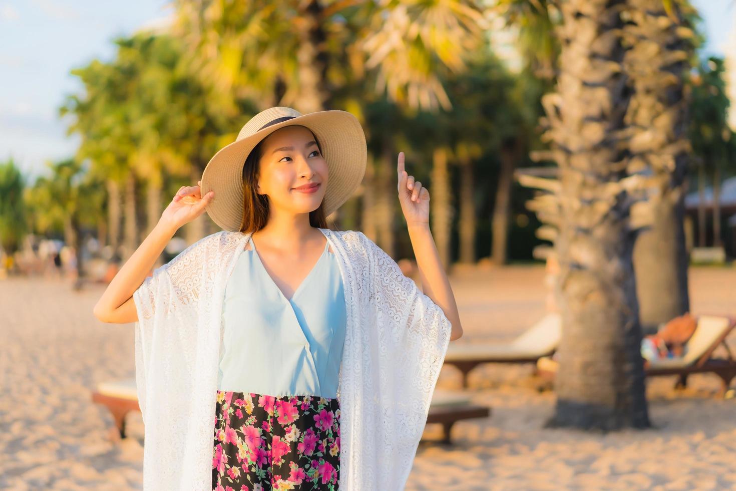 ritratto belle giovani donne asiatiche sorriso felice rilassarsi intorno alla spiaggia mare oceano foto