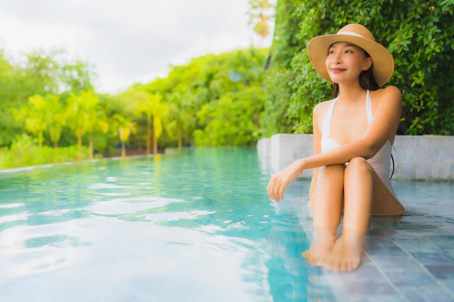 ritratto belle giovani donne asiatiche sorriso felice rilassarsi intorno alla piscina all'aperto in hotel foto