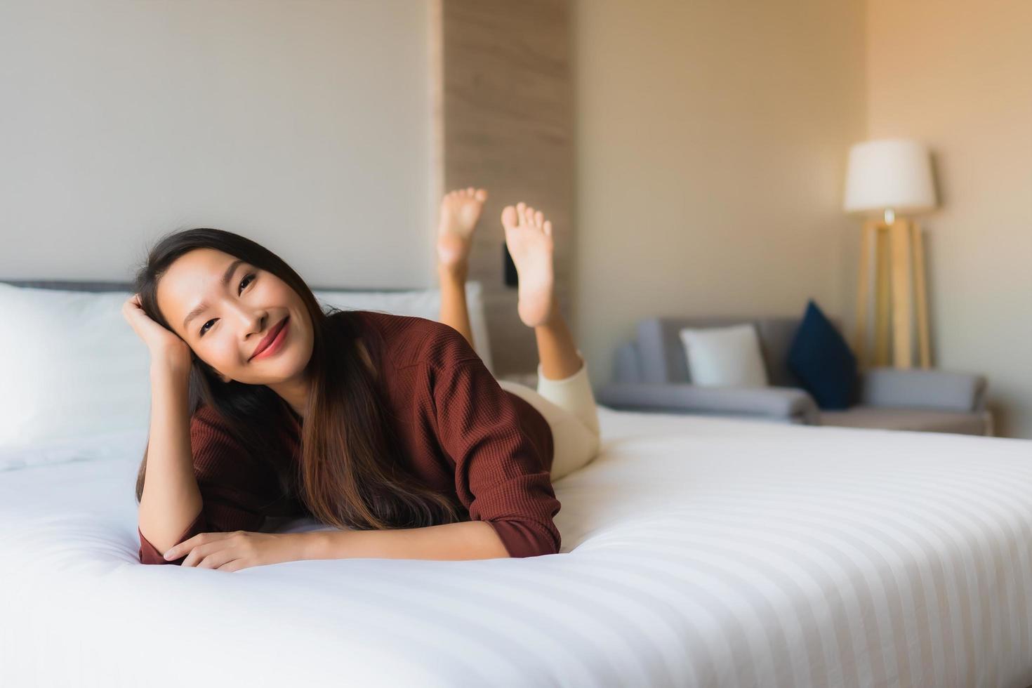 ritratto belle giovani donne asiatiche sorriso felice rilassarsi sul letto foto