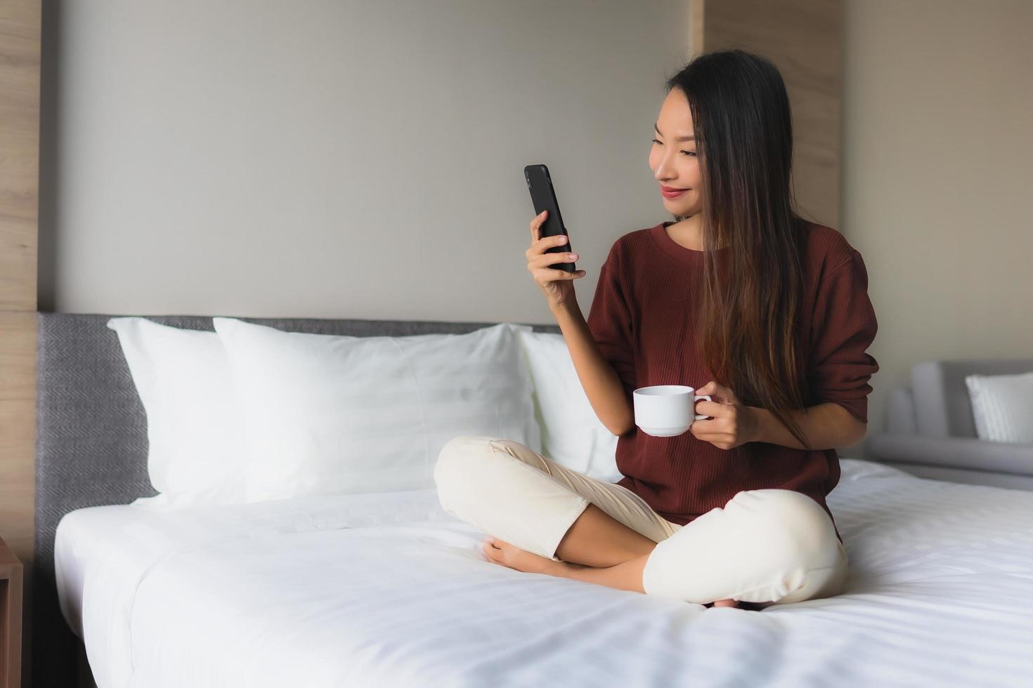 ritratto belle giovani donne asiatiche sorriso felice con caffè e telefono cellulare foto