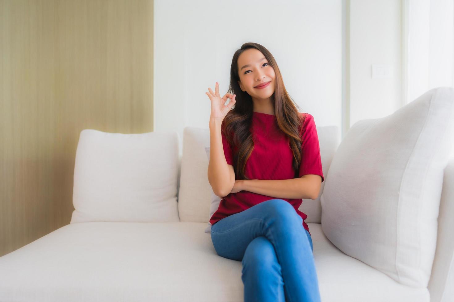 ritratto belle giovani donne asiatiche sorriso felice sedersi sul divano foto