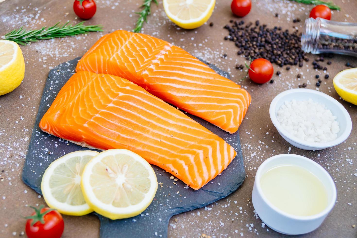 filetto di carne di salmone crudo e fresco su ardesia di pietra nera foto