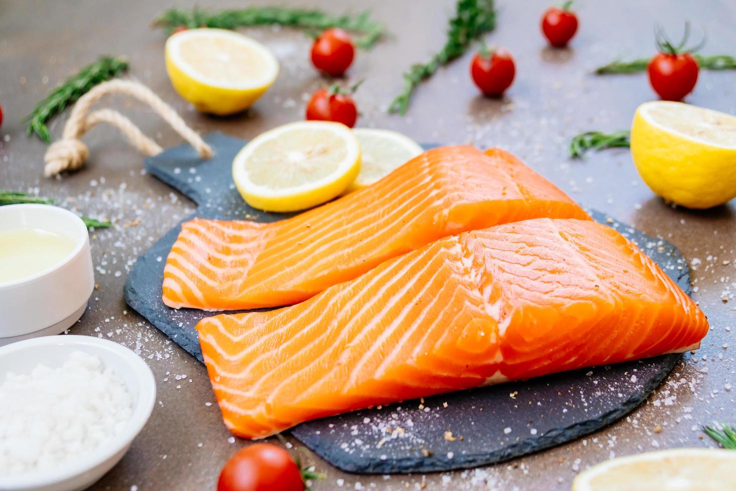 filetto di carne di salmone crudo e fresco su ardesia di pietra nera foto