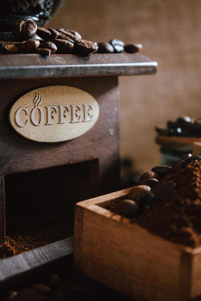 natura morta con chicchi di caffè e vecchio mulino da caffè sullo sfondo rustico foto