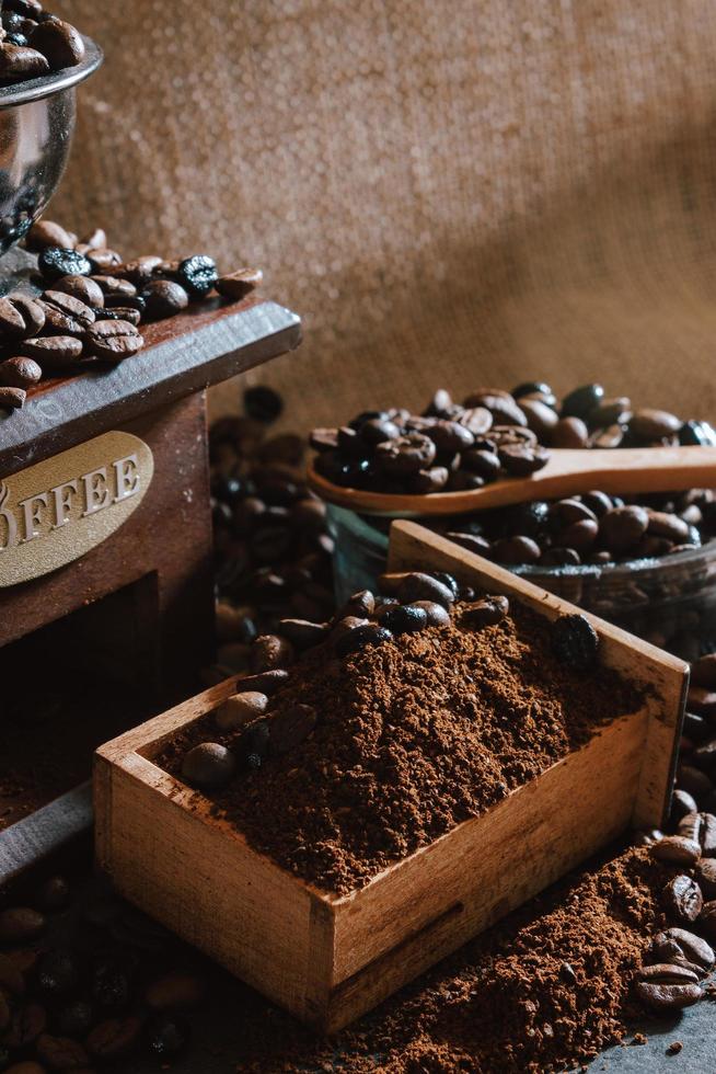 natura morta con chicchi di caffè e vecchio mulino da caffè sullo sfondo rustico foto