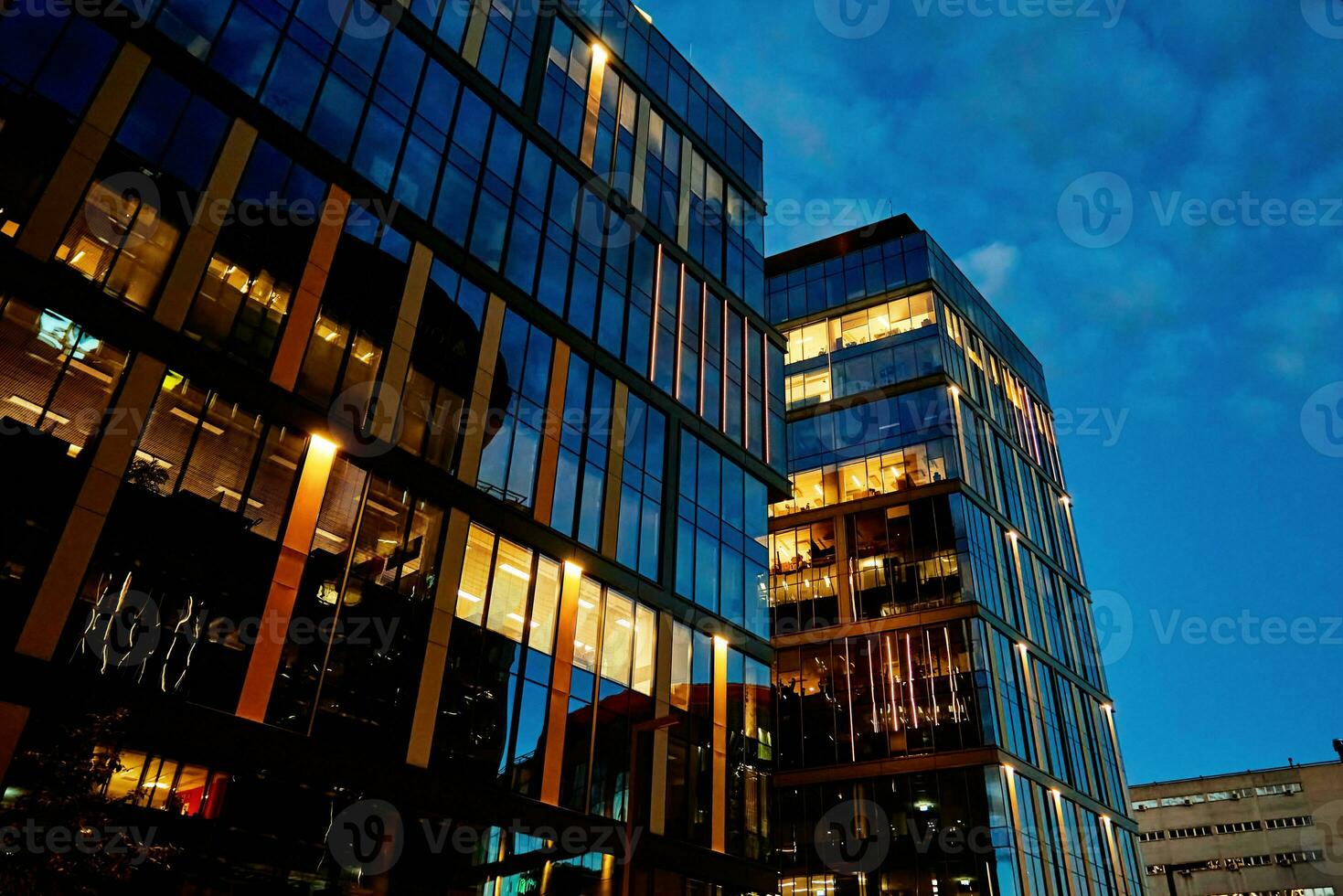 alto salire ufficio edificio con illuminato finestre a notte foto