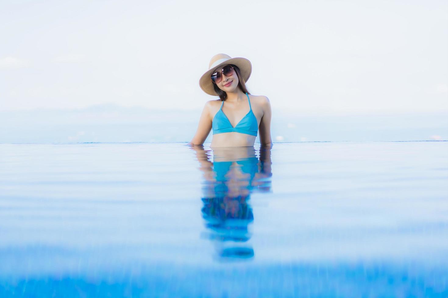 ritratto belle giovani donne asiatiche sorriso felice relax piscina all'aperto nel resort foto
