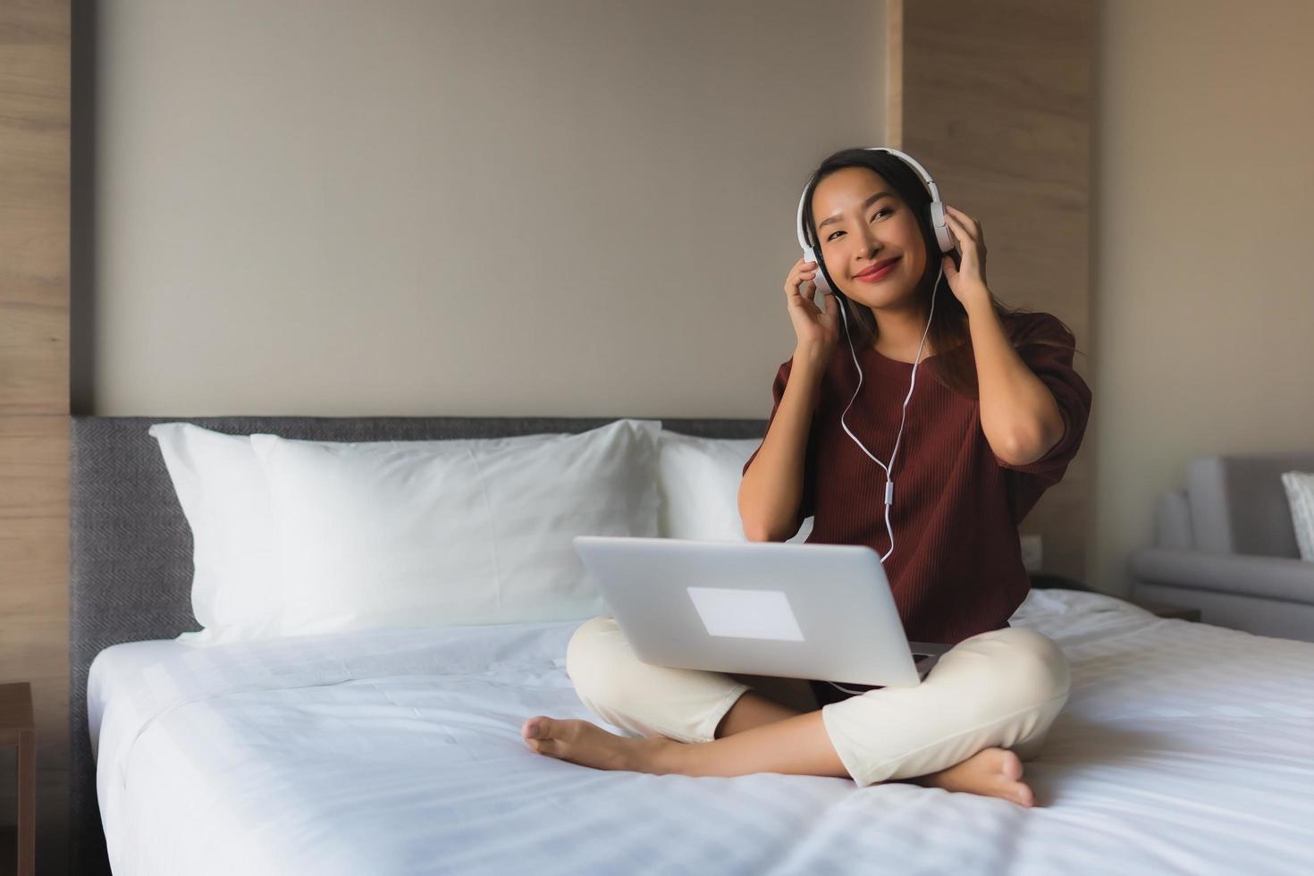 ritratto belle giovani donne asiatiche che utilizzano computer e cuffie per ascoltare musica foto