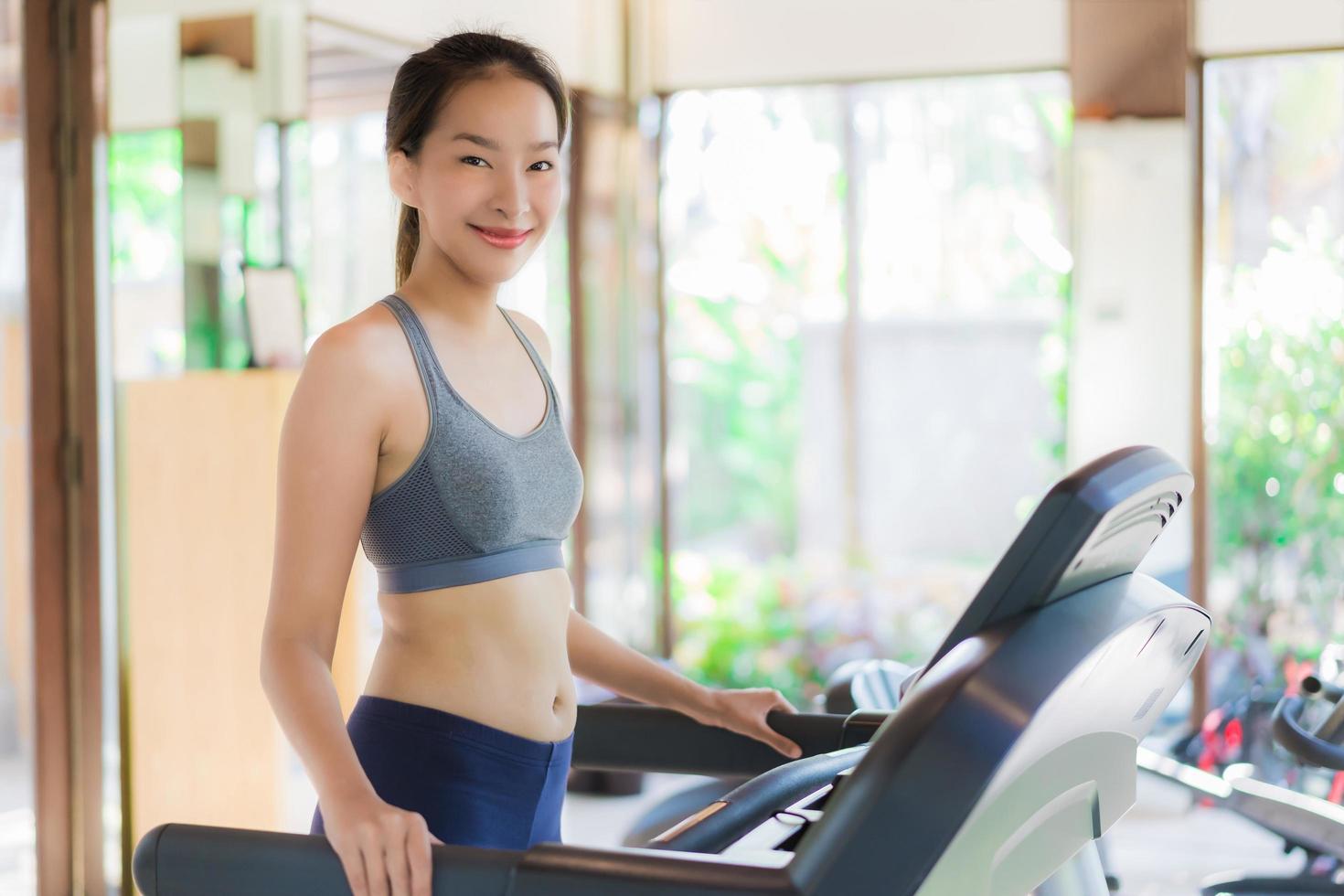 ritratto bella giovane donna asiatica esercizio con attrezzature per il fitness in palestra interior foto