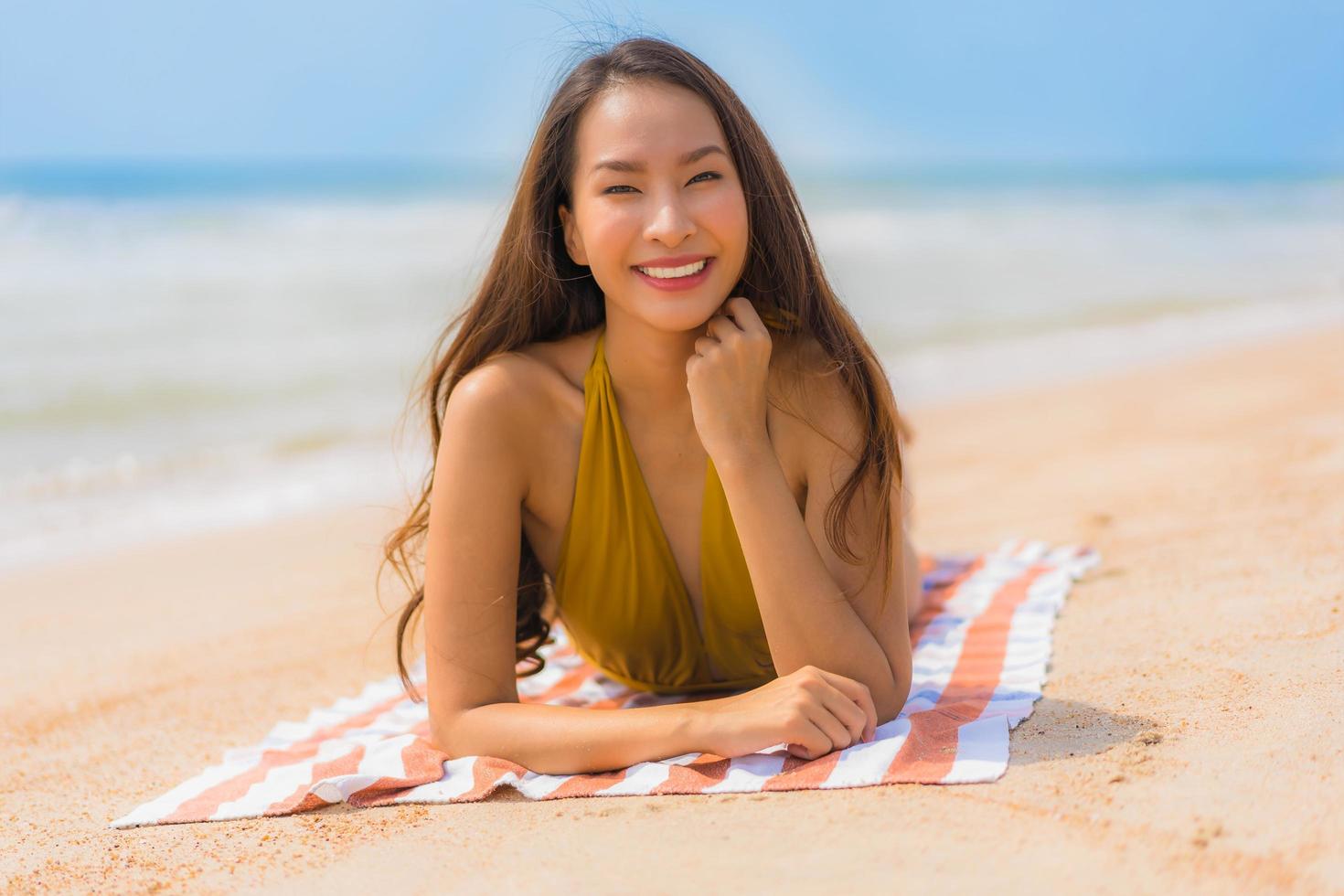 ritratto bella giovane donna asiatica sorriso felice sulla spiaggia e sul mare foto