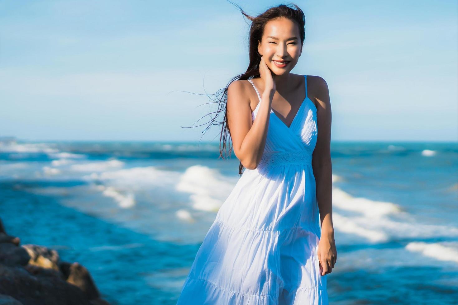 ritratto bella giovane donna asiatica sorriso felice rilassarsi intorno alla spiaggia e al mare vicini foto
