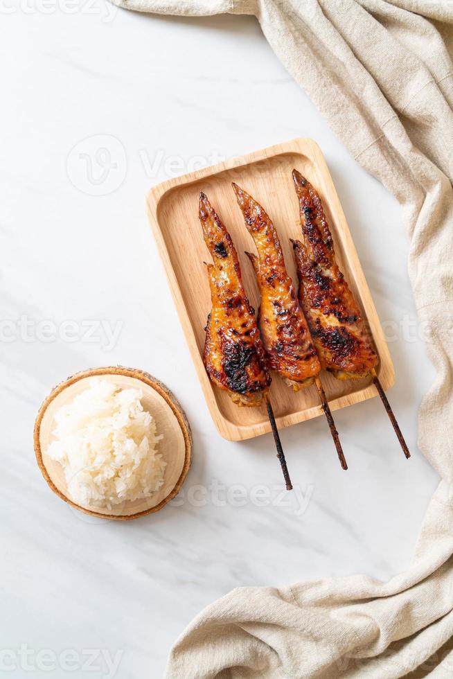 spiedino di ali di pollo alla griglia o barbecue con riso appiccicoso foto