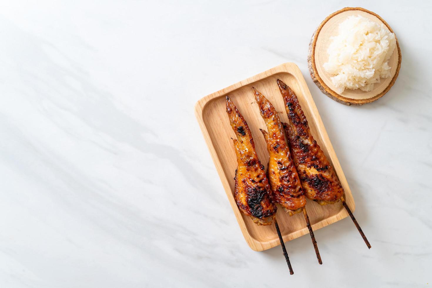 spiedino di ali di pollo alla griglia o barbecue con riso appiccicoso foto