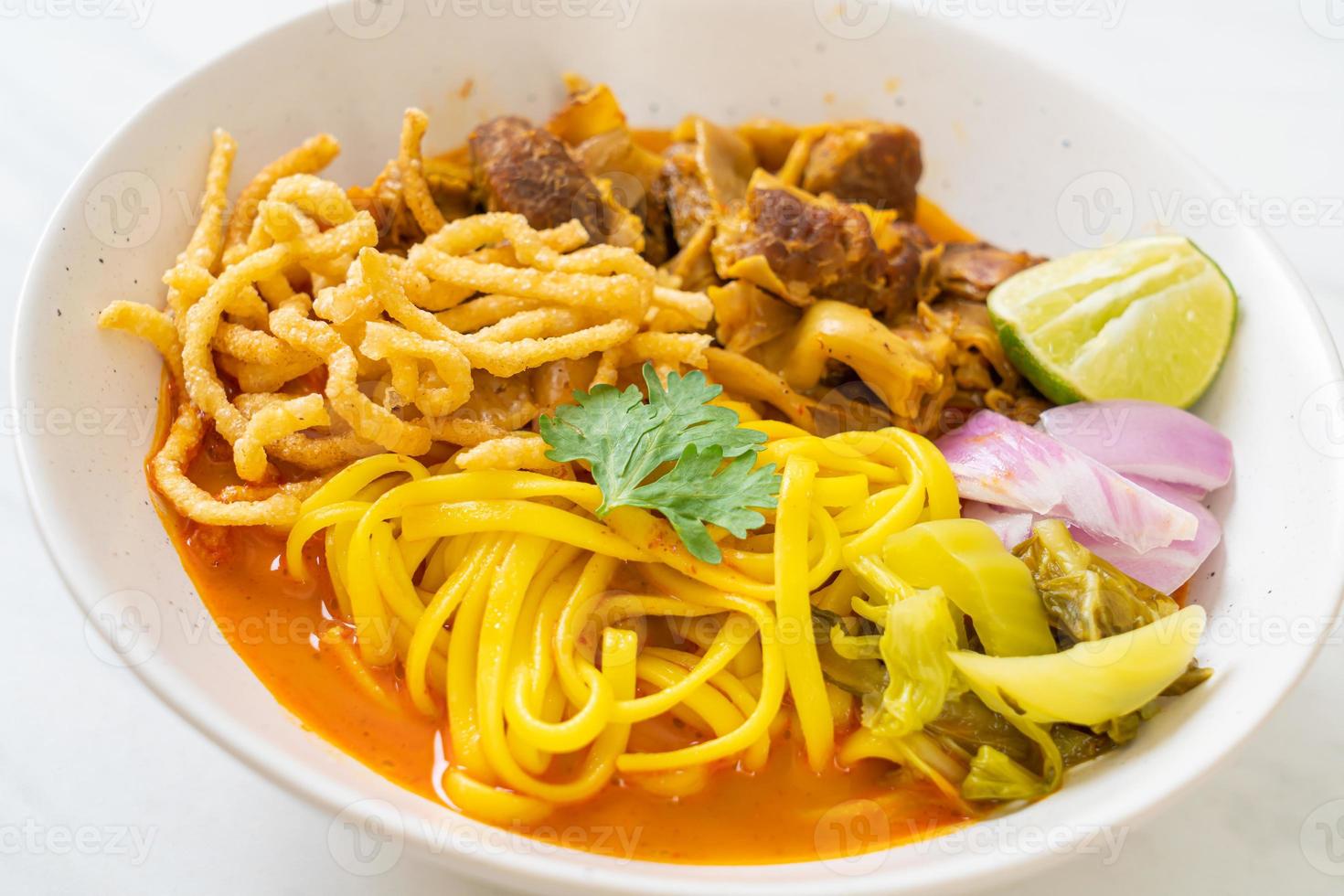 zuppa di noodle al curry del nord della Thailandia con maiale brasato foto