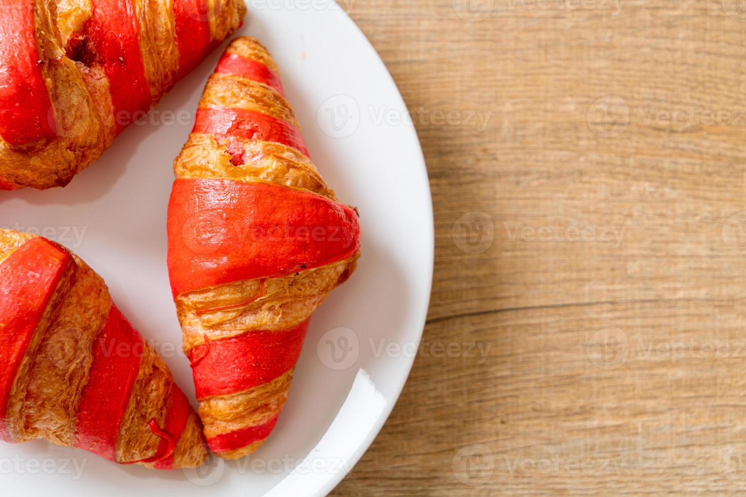 croissant fresco con salsa di marmellata di fragole sul piatto foto