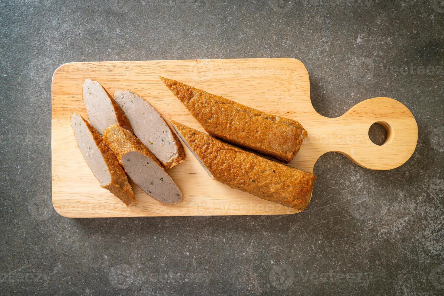 torta di pesce cinese fritta o linea di polpette di pesce su tavola di legno foto