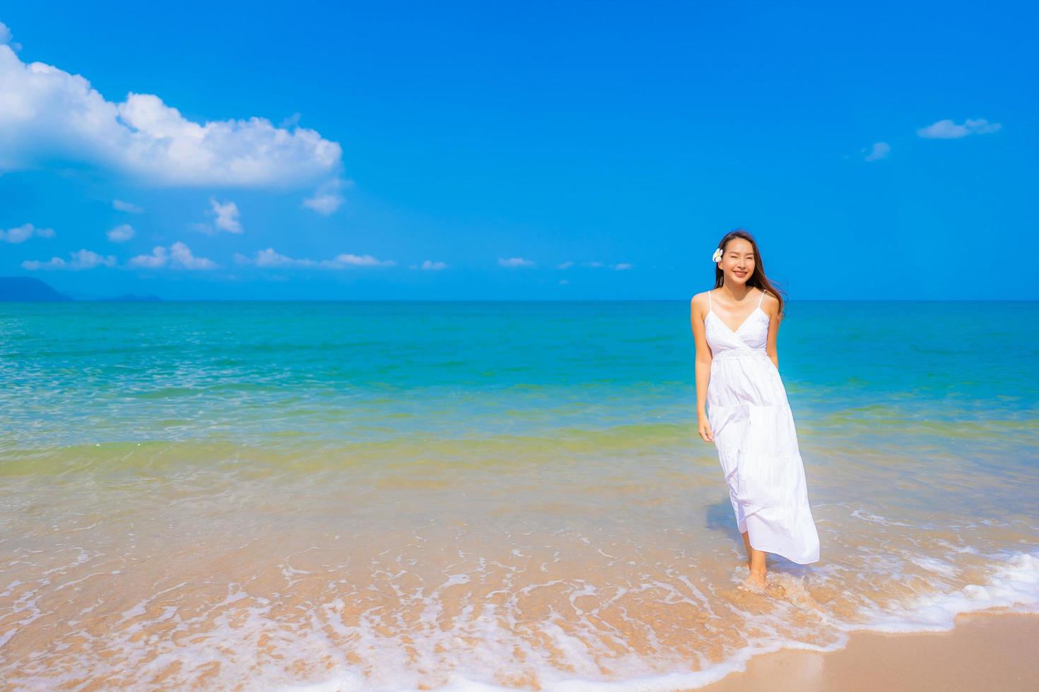 ritratto bella giovane donna asiatica sorriso felice tempo libero sulla spiaggia mare e oceano foto