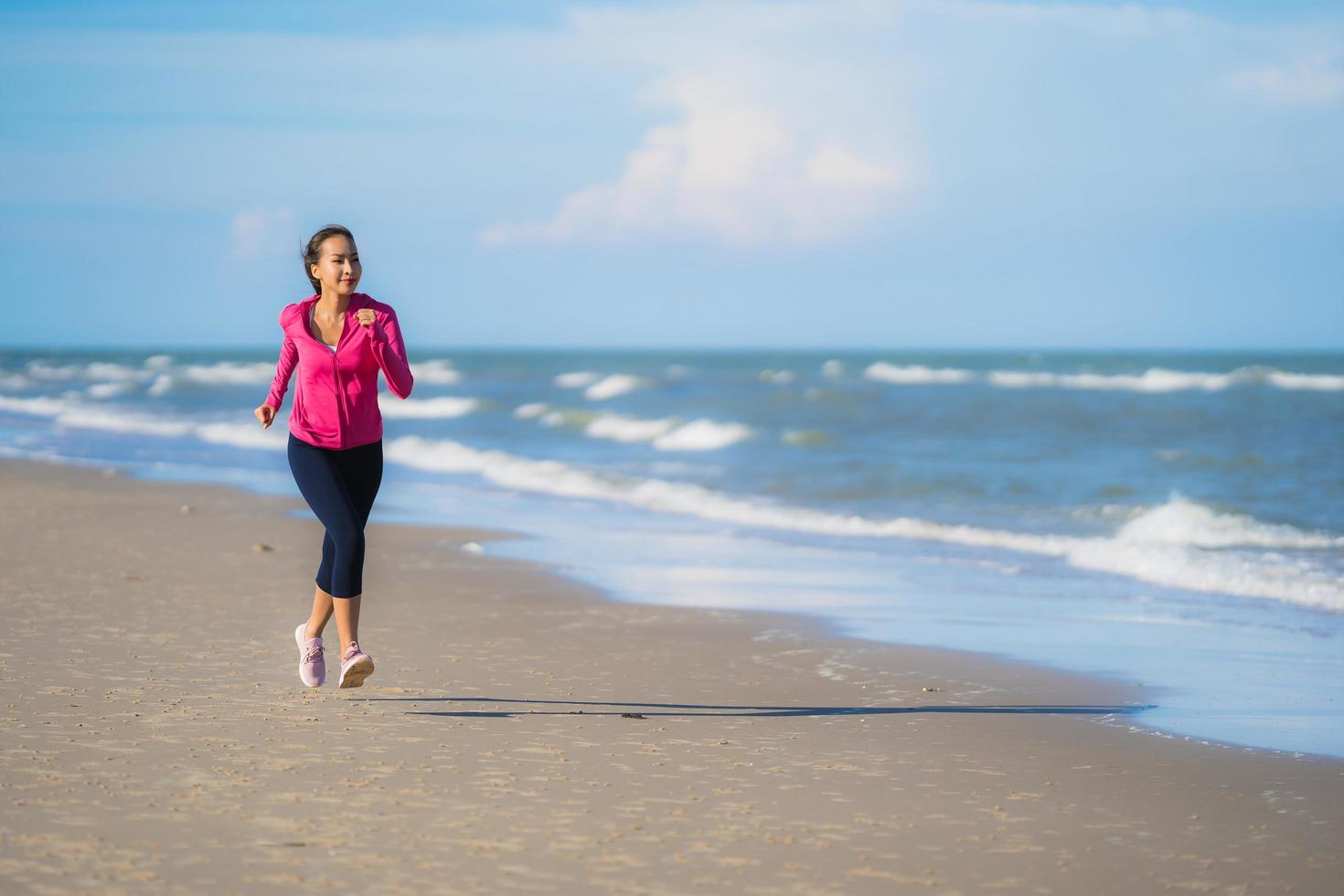 ritratto bella giovane donna asiatica che corre e si esercita sulla natura tropicale all'aperto spiaggia mare oceano foto