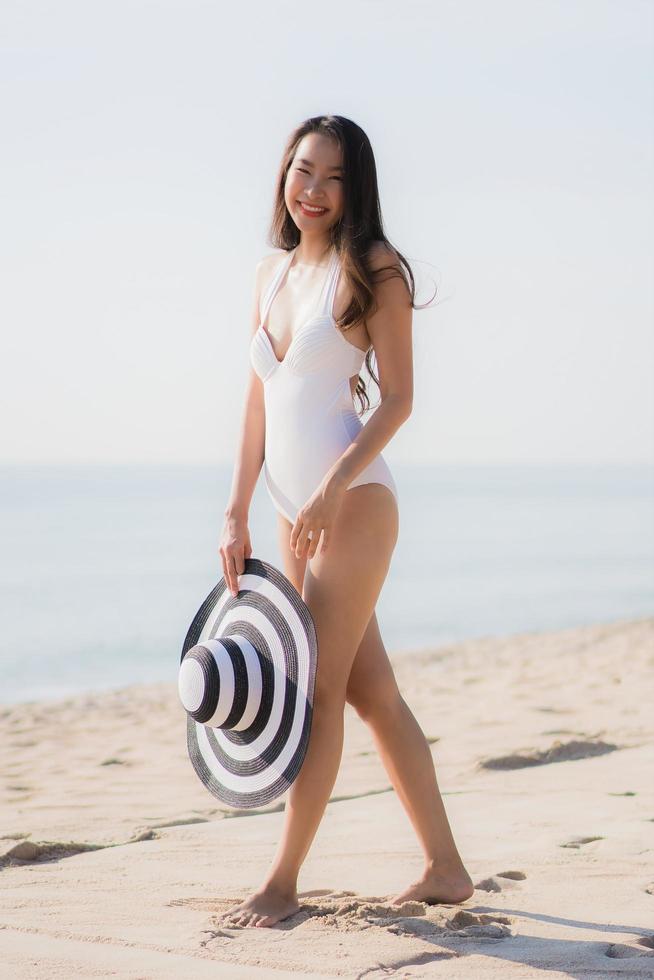 ritratto bella giovane donna asiatica felice e sorridente sulla spiaggia mare e oceano foto