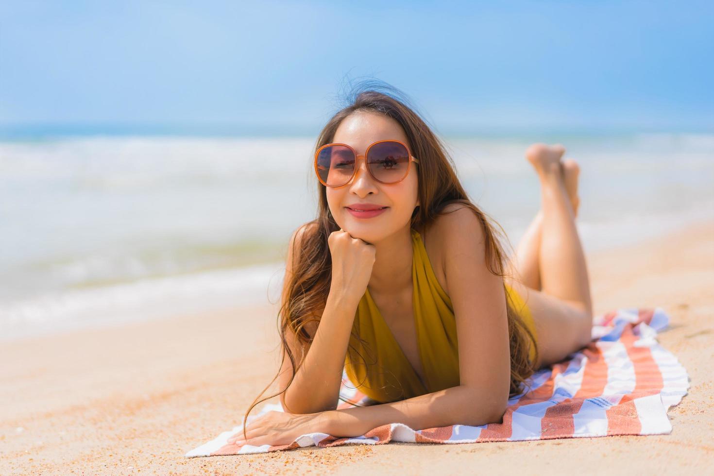 ritratto bella giovane donna asiatica sorriso felice sulla spiaggia e sul mare foto