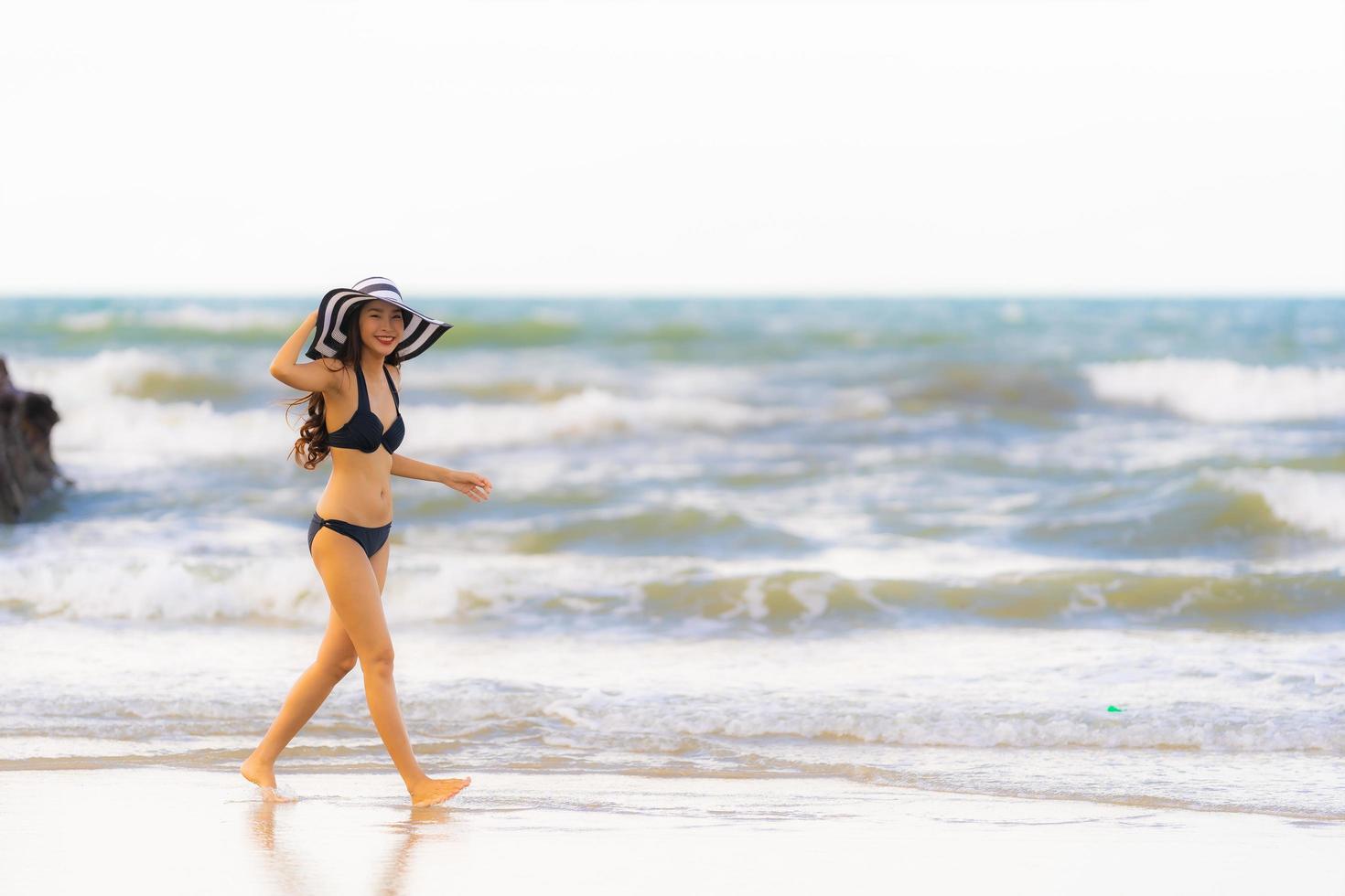 ritratto bella giovane donna asiatica indossare bikini sulla spiaggia mare oceano foto