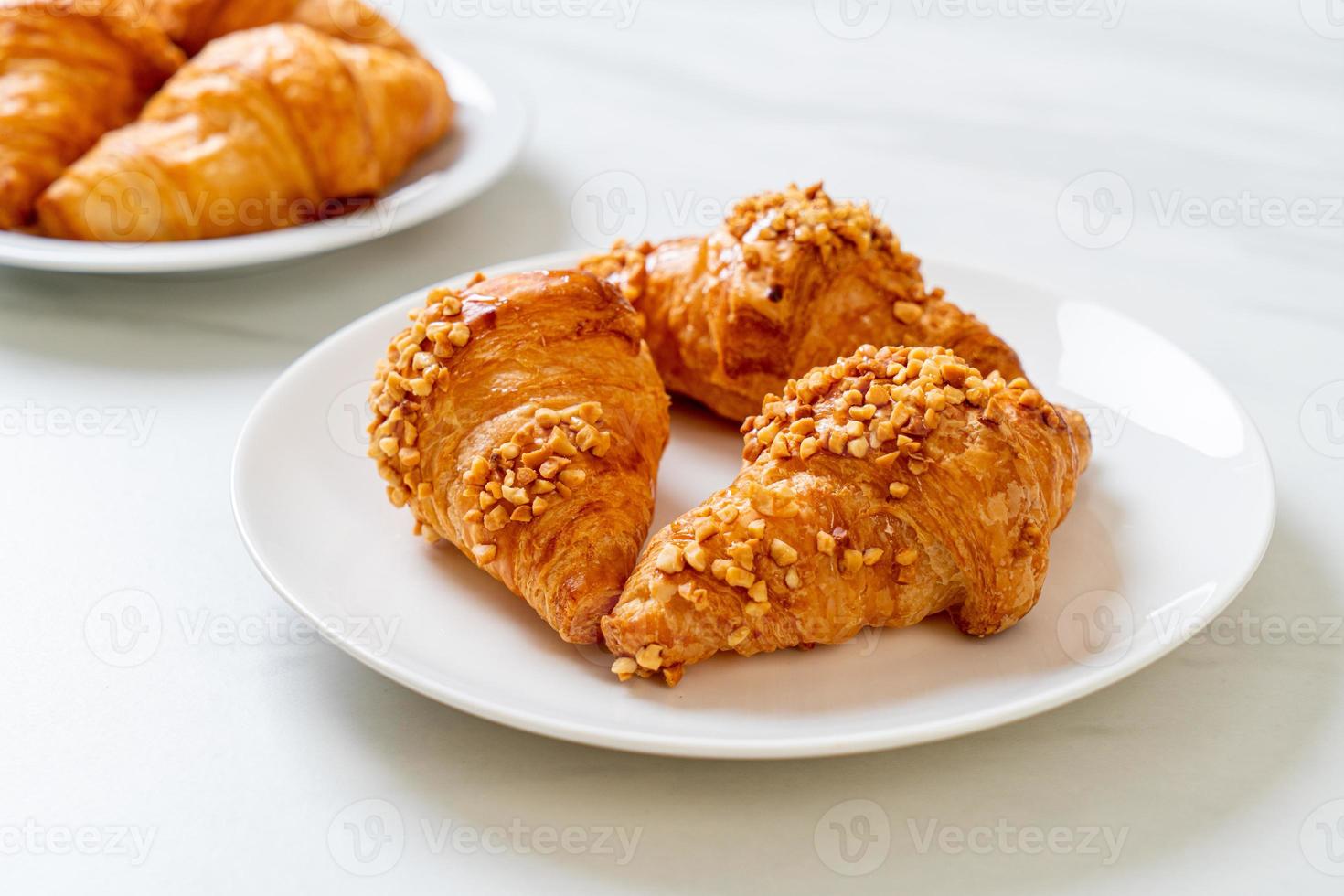 croissant fresco con arachidi sul piatto foto