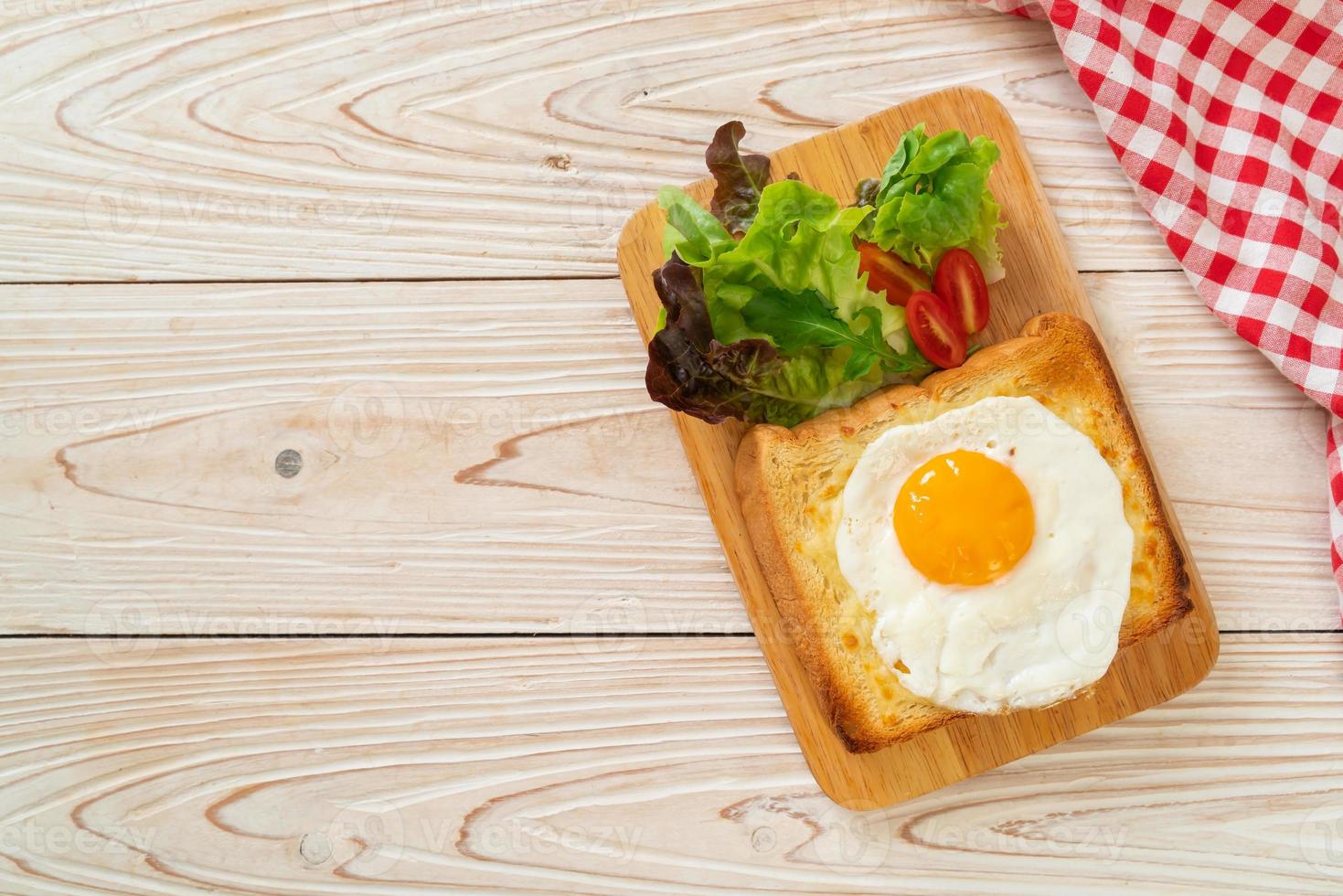 pane casereccio tostato con formaggio e uovo fritto sopra con insalata di verdure per colazione foto