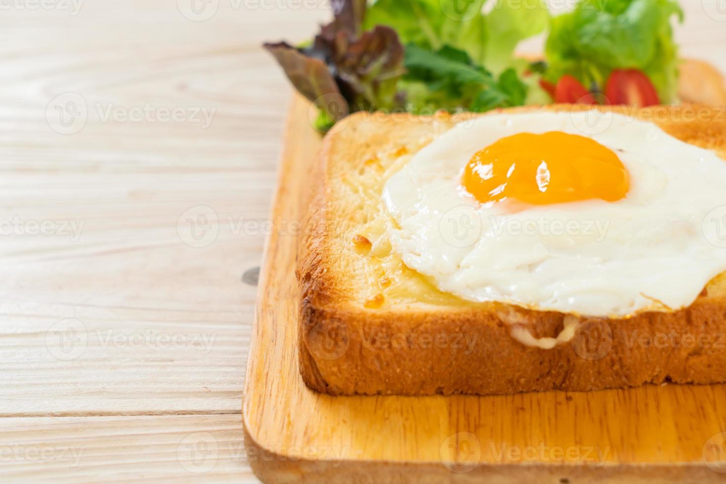 pane casereccio tostato con formaggio e uovo fritto sopra con insalata di verdure per colazione foto