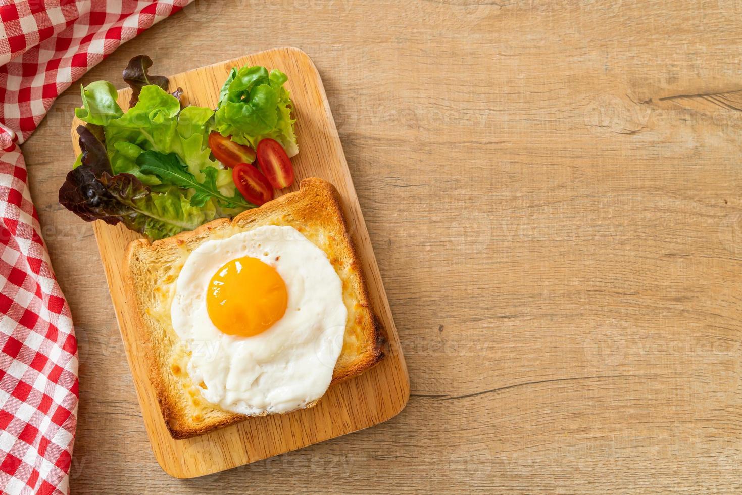 pane casereccio tostato con formaggio e uovo fritto sopra con insalata di verdure per colazione foto