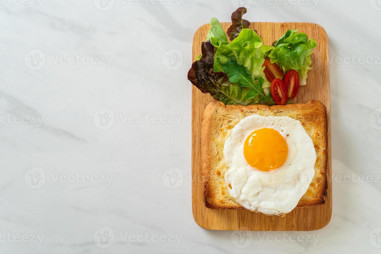 pane casereccio tostato con formaggio e uovo fritto sopra con insalata di verdure per colazione foto