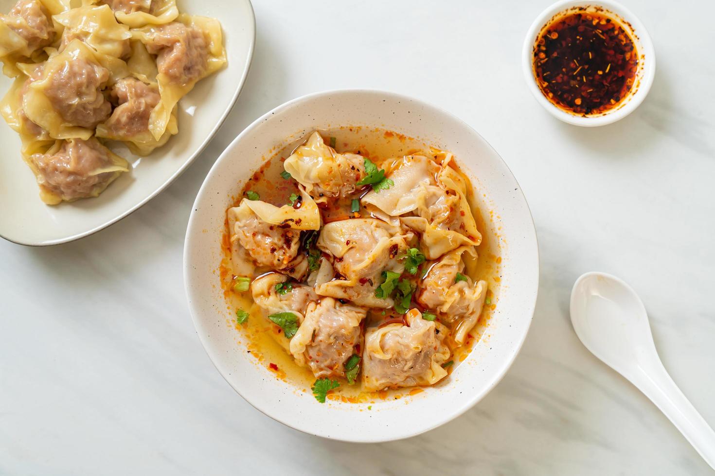 zuppa di wonton di maiale o zuppa di gnocchi di maiale con peperoncino arrosto - stile asiatico foto