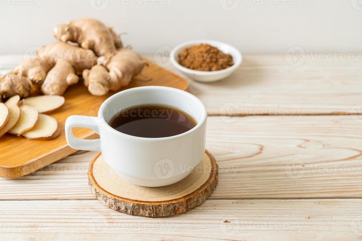 bicchiere di succo di zenzero caldo e dolce con radici di zenzero - stile bevanda salutare foto