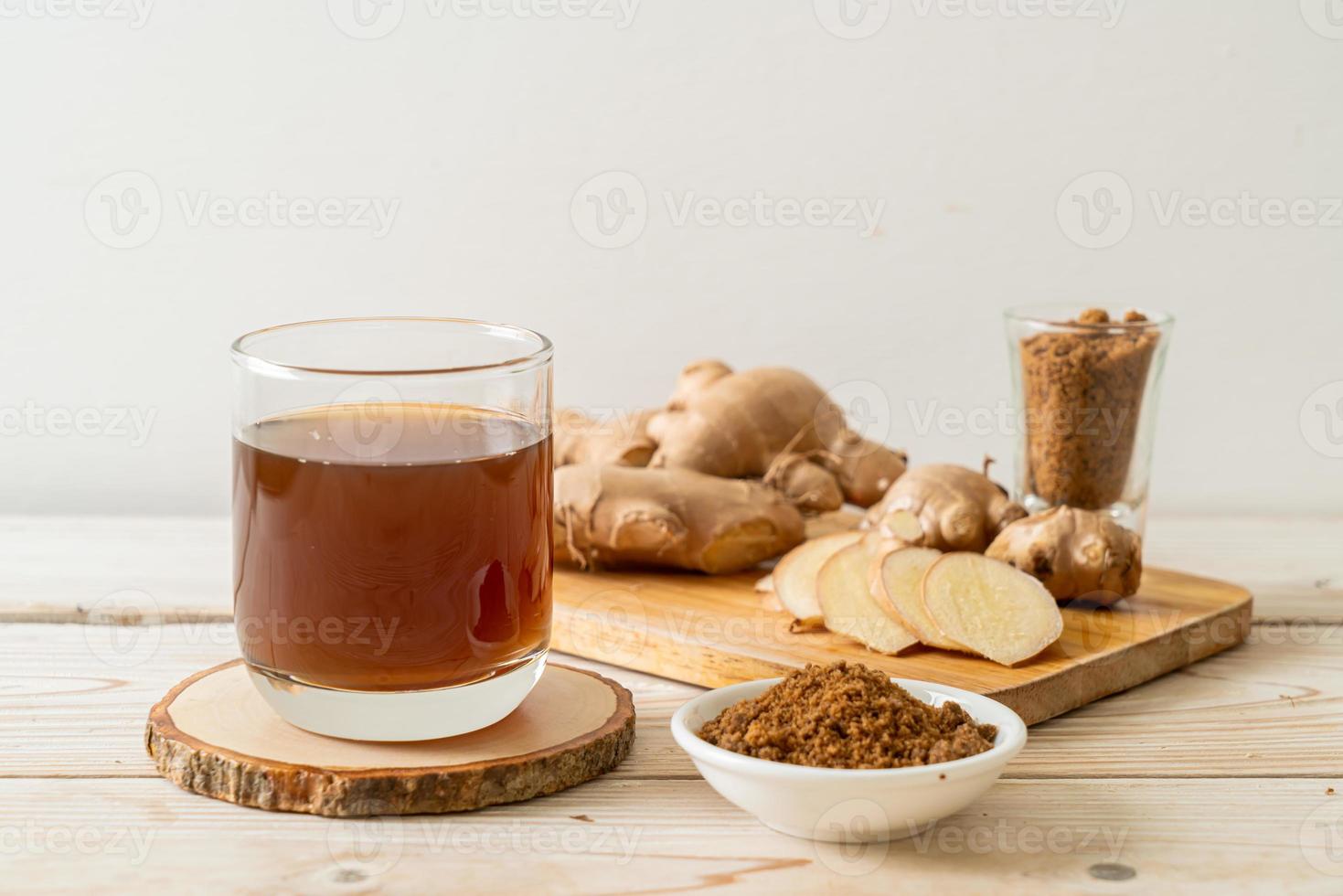 bicchiere di succo di zenzero caldo e dolce con radici di zenzero - stile bevanda salutare foto