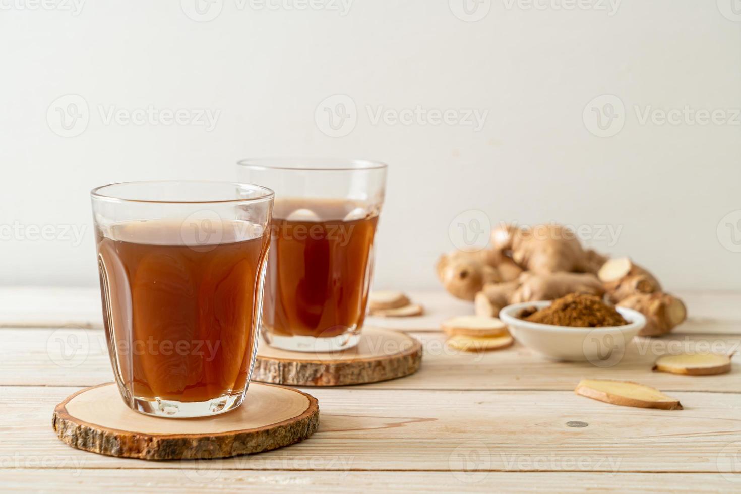 bicchiere di succo di zenzero caldo e dolce con radici di zenzero - stile bevanda salutare foto