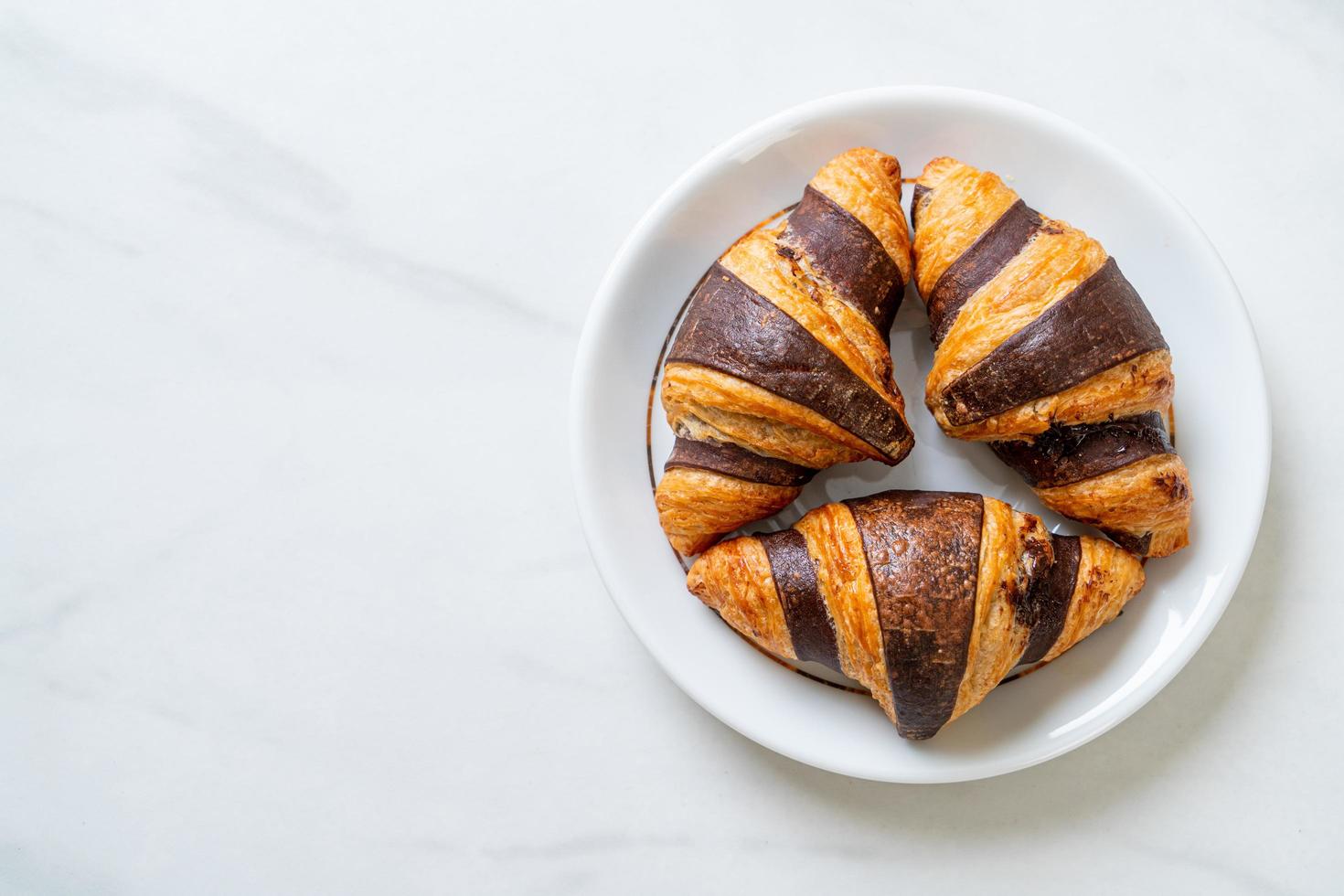 croissant fresco al cioccolato su piatto foto