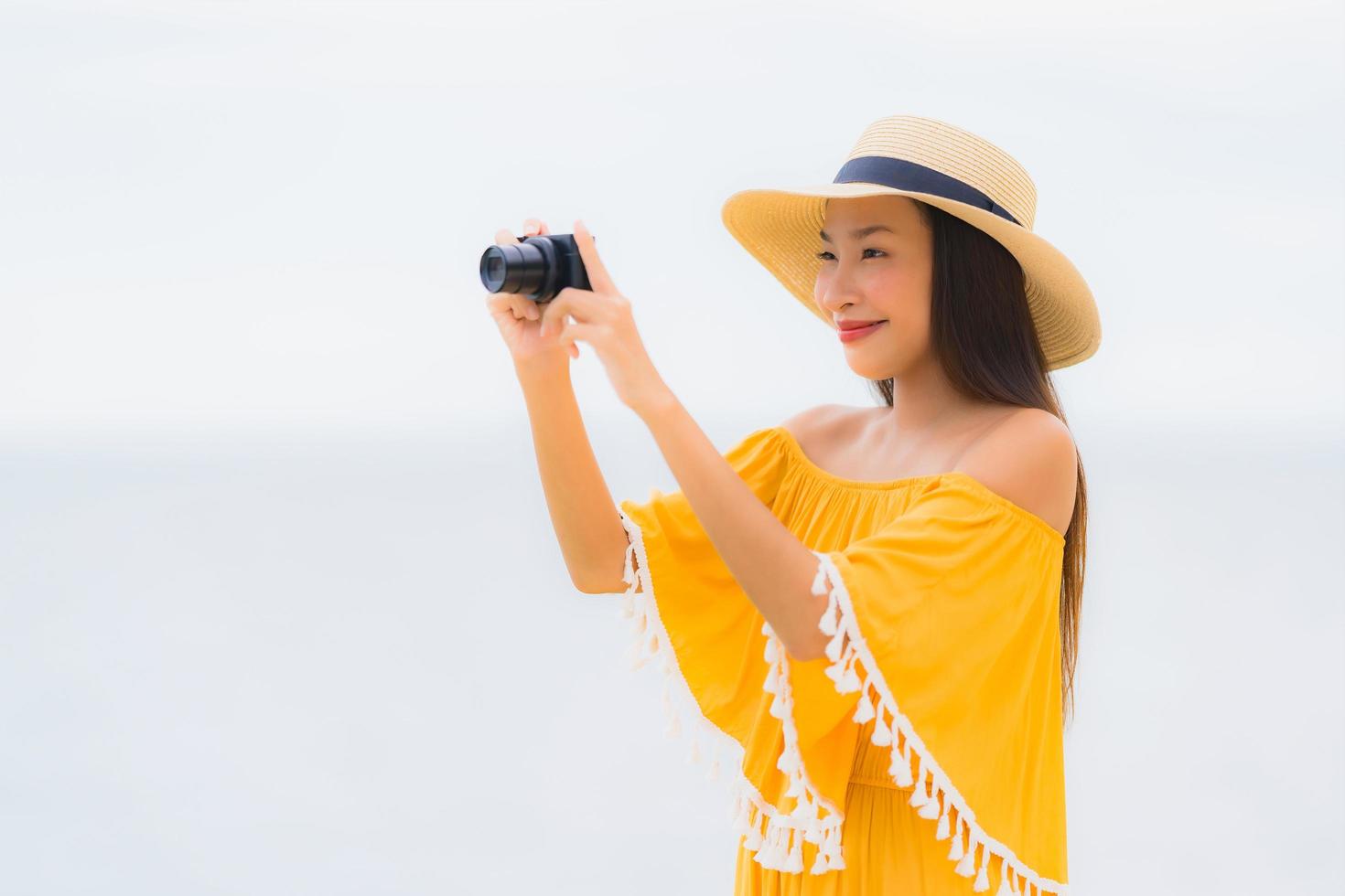 ritratto bella donna asiatica indossare cappello con sorriso felice tempo libero per scattare una foto sulla spiaggia e sul mare in vacanza