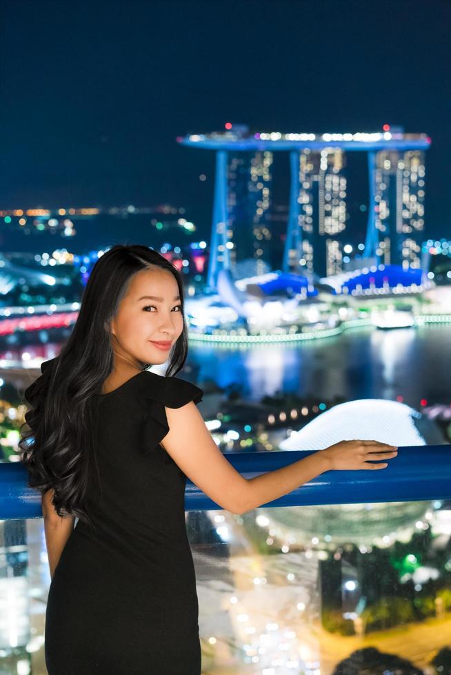 le belle donne asiatiche sorridono e sono felici con la vista della città di Singapore foto