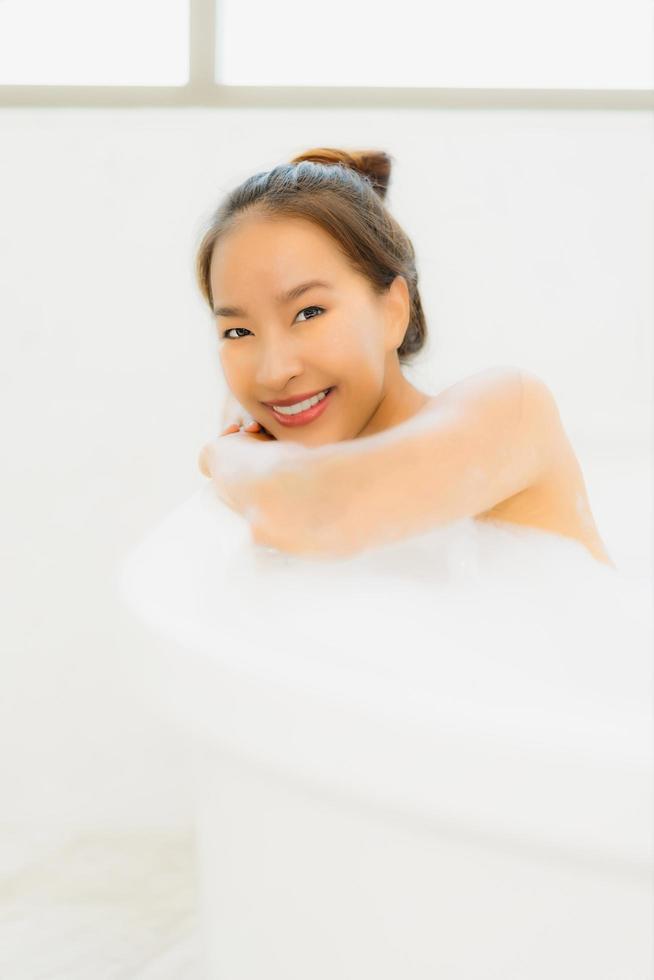 ritratto bella giovane donna asiatica prendere una vasca da bagno in bagno foto