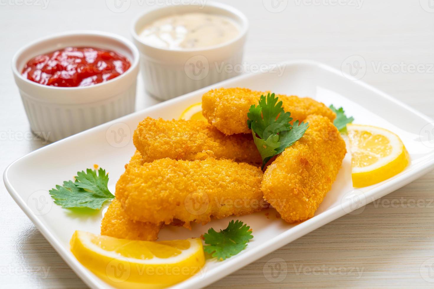 bastoncini di pesce fritti o patatine fritte di pesce con salsa foto