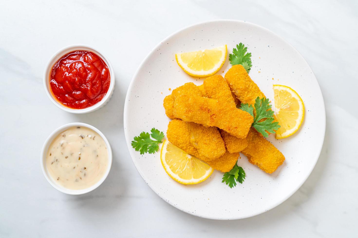 bastoncini di pesce fritti o patatine fritte di pesce con salsa foto