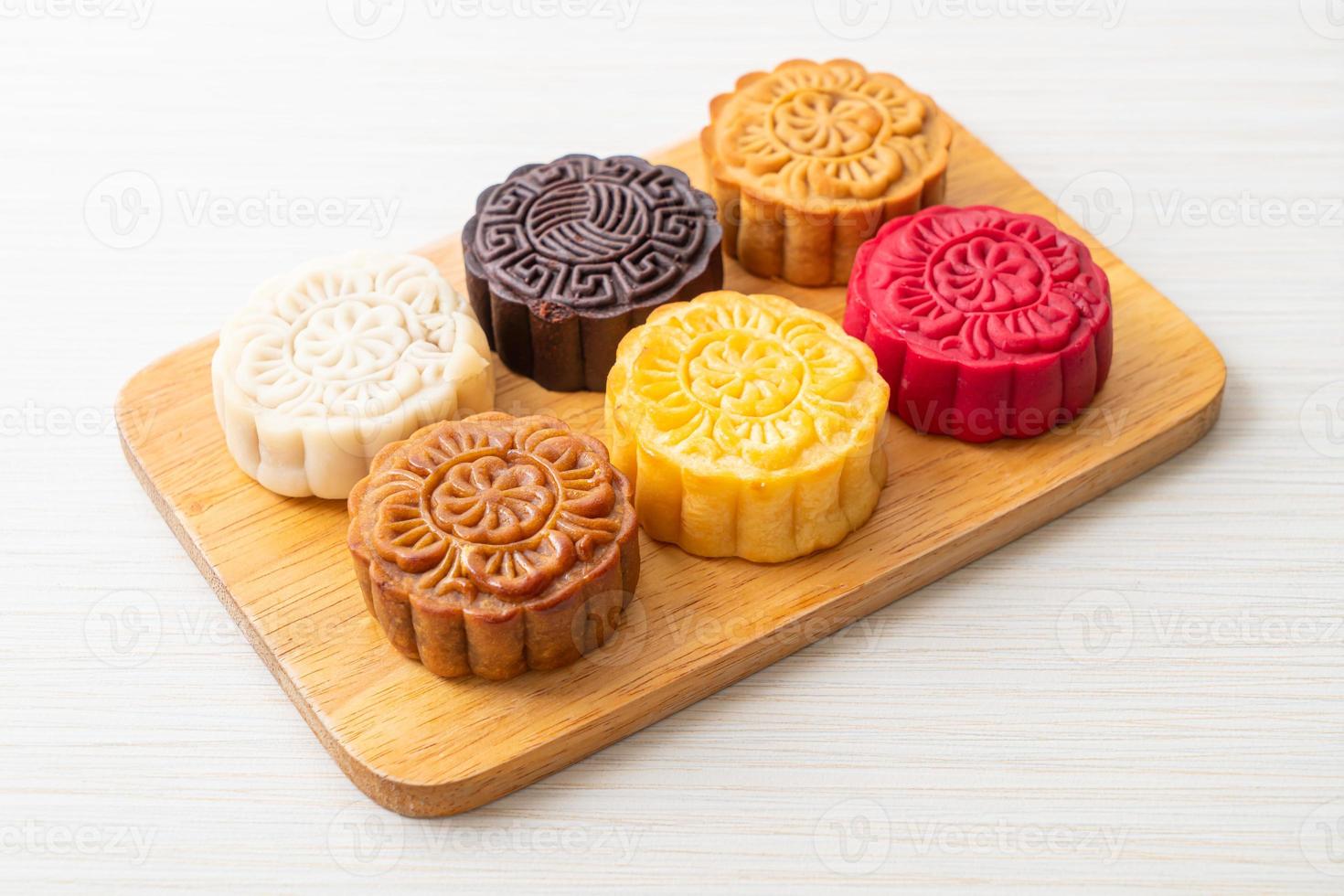 torta luna cinese colorata con sapore misto su piatto di legno foto