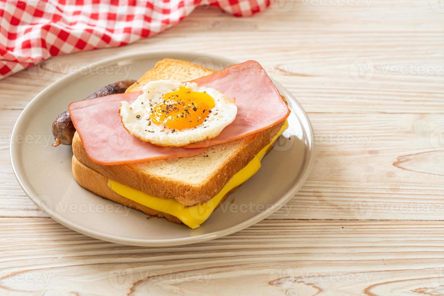pane fatto in casa formaggio tostato condita con prosciutto e uovo fritto con salsiccia di maiale per colazione foto