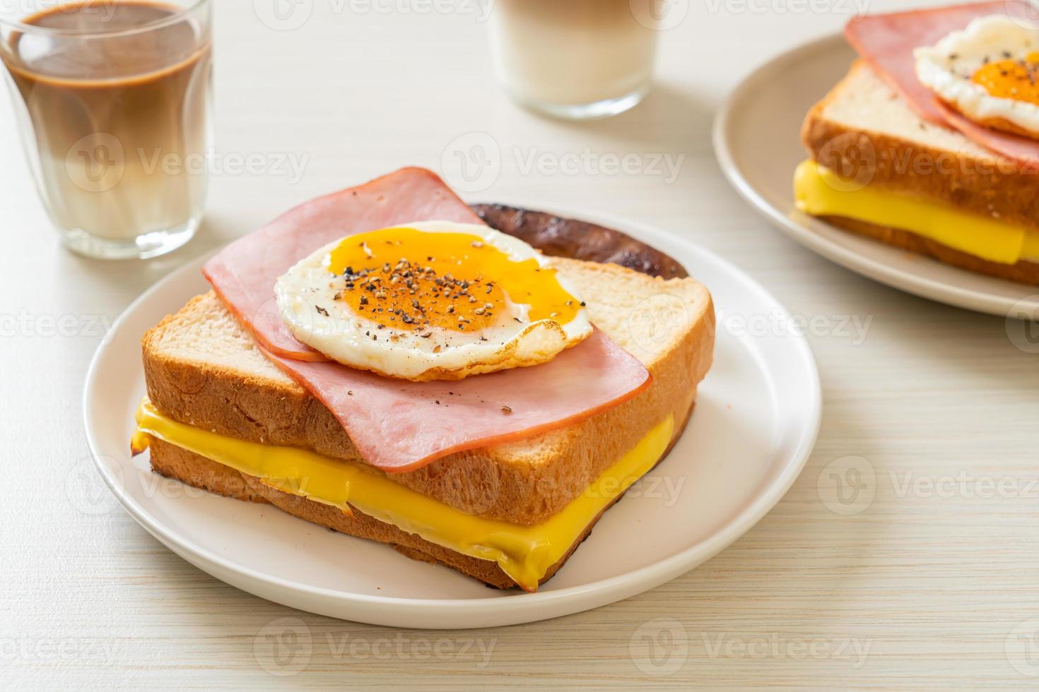 pane fatto in casa formaggio tostato, prosciutto cotto e uovo fritto con salsiccia di maiale a colazione foto