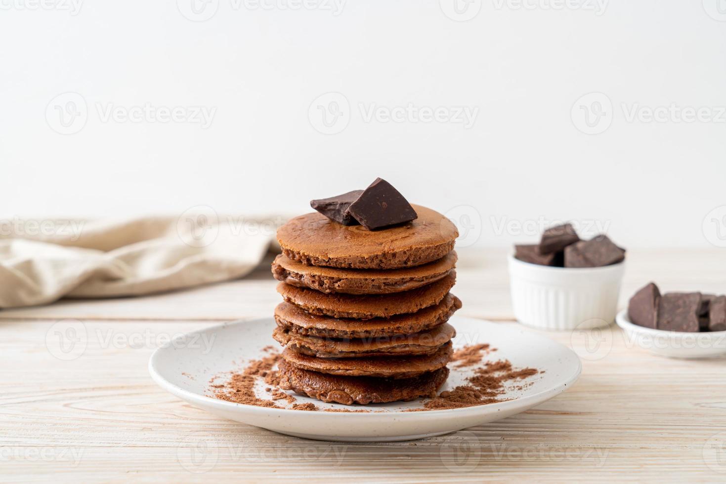 pila di pancake al cioccolato con cioccolato in polvere foto