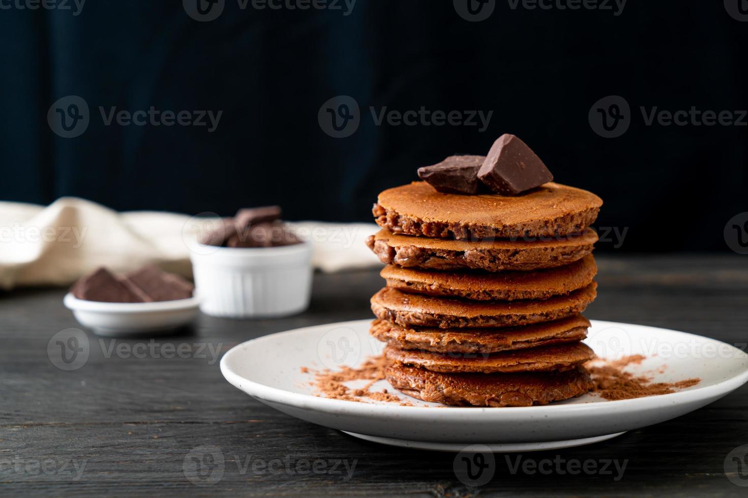 pila di pancake al cioccolato con cioccolato in polvere foto