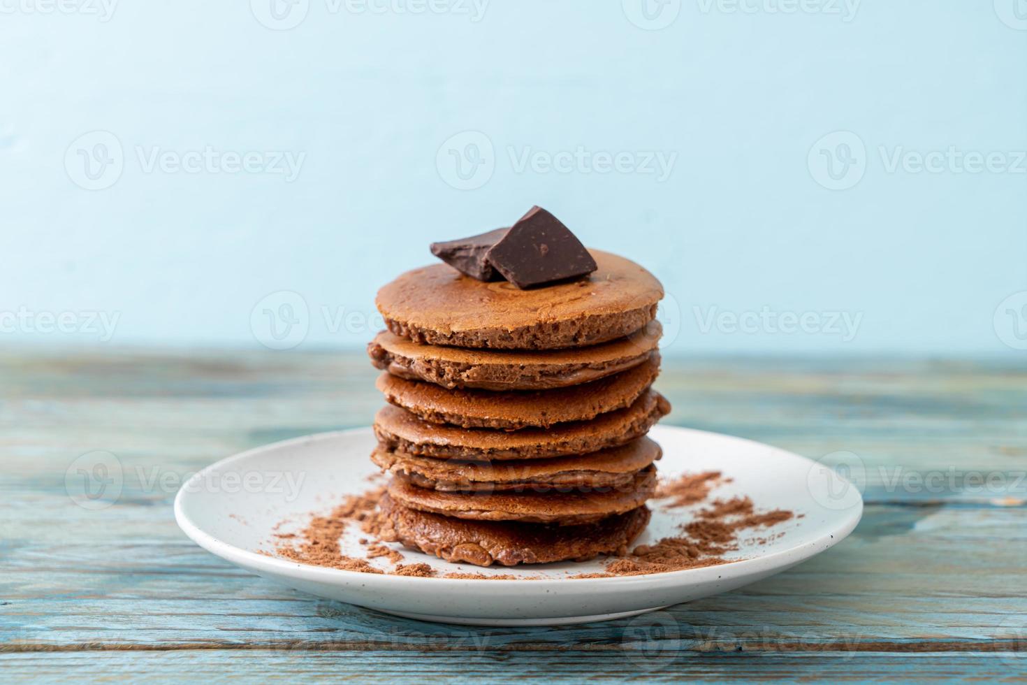 pila di pancake al cioccolato con cioccolato in polvere foto