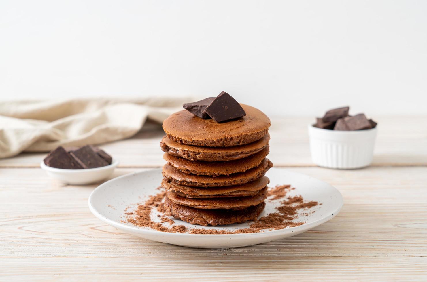 pila di pancake al cioccolato con cioccolato in polvere foto