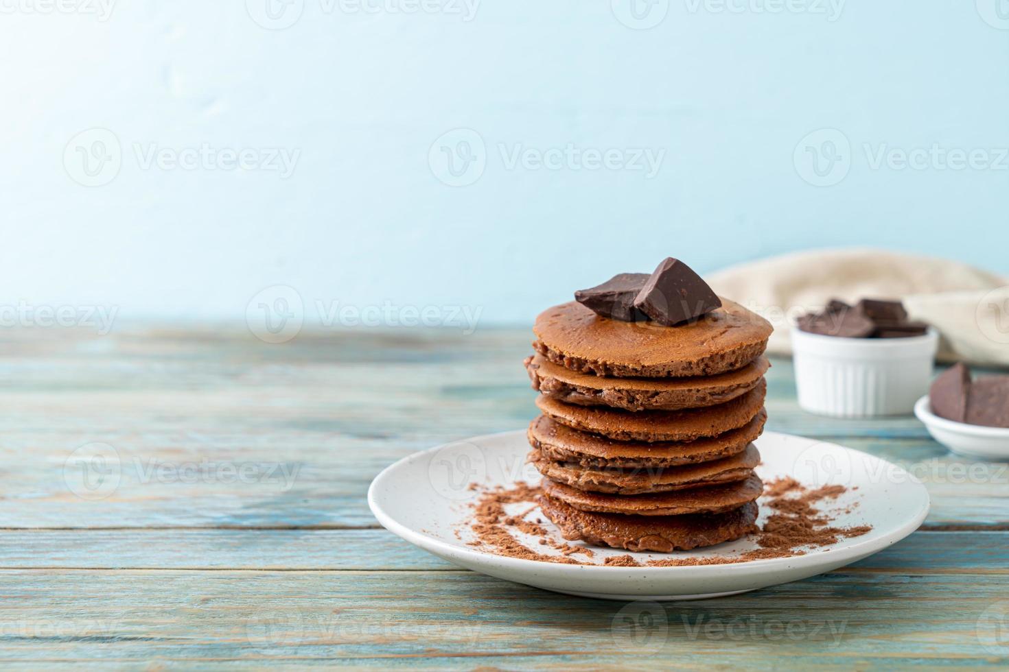 pila di pancake al cioccolato con cioccolato in polvere foto